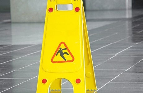 Wet floor sign suggesting Liability insurance