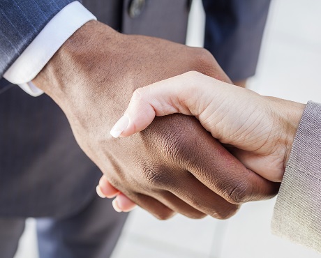 Two suited people shaking hands celebrating business continuity | Kerry London team