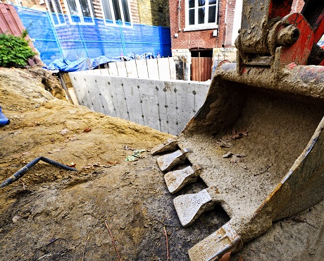 Basement being constructed with digger in foreground representing contract works insurance