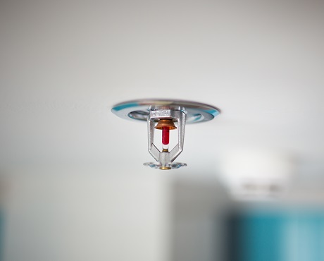 Close up of water sprinkler on a white ceiling representing Efficacy insurance